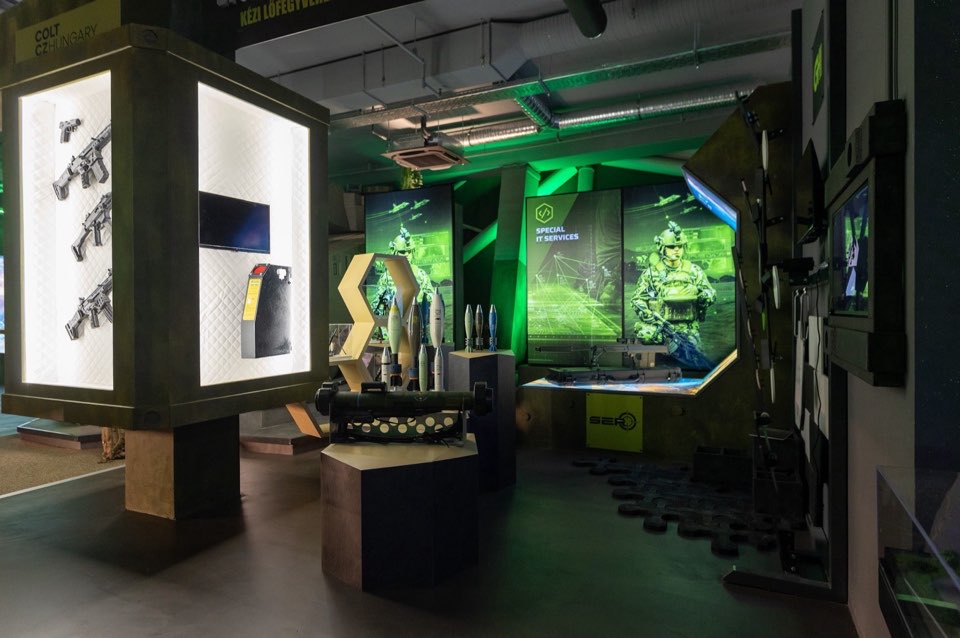 Exhibition hall with illuminated display cases and a green-lit installation.