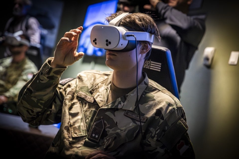 A visitor in a camouflage jacket using a virtual reality headset.