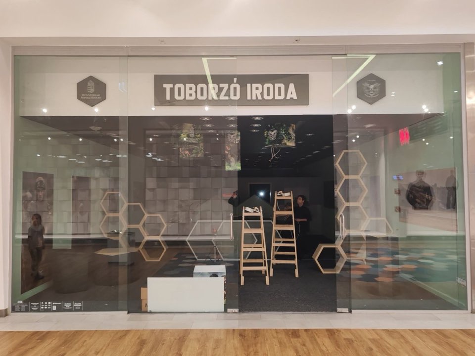 The glazed shopfront of a recruitment office during fit-out, with ladders inside.